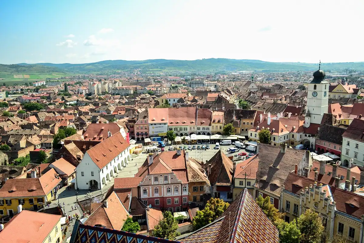 Orașul Sibiu văzut de sus, cu piața mare, turnul Sfatului și acoperișuri roșii